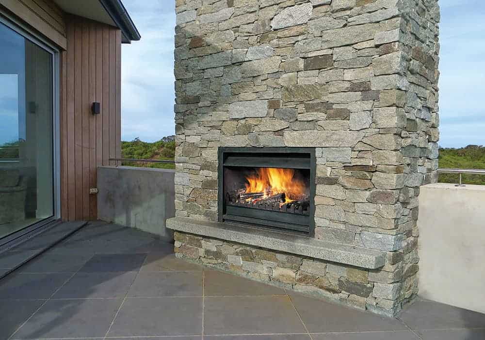 Warm outdoor fireplace with stone surround, ideal for cosy evenings on a modern terrace.